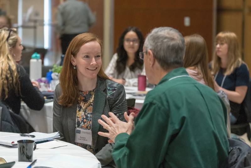 Two people talking at a conference