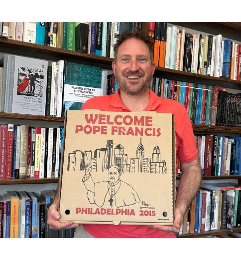 Dr. DiGiovine holding book that says Welcome Pope Francis 2015