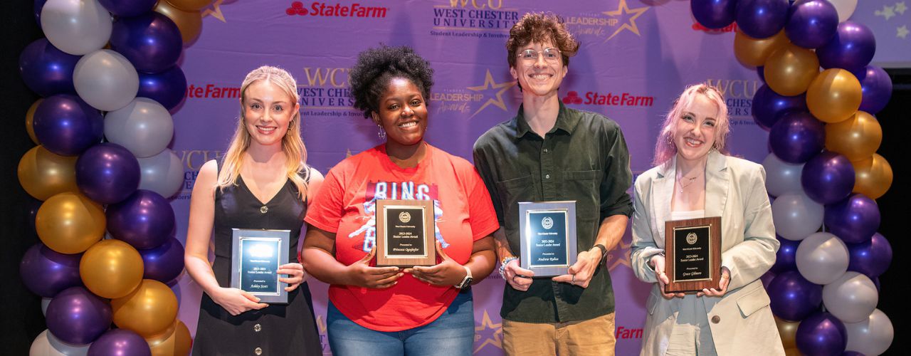 four students holding leadership awards