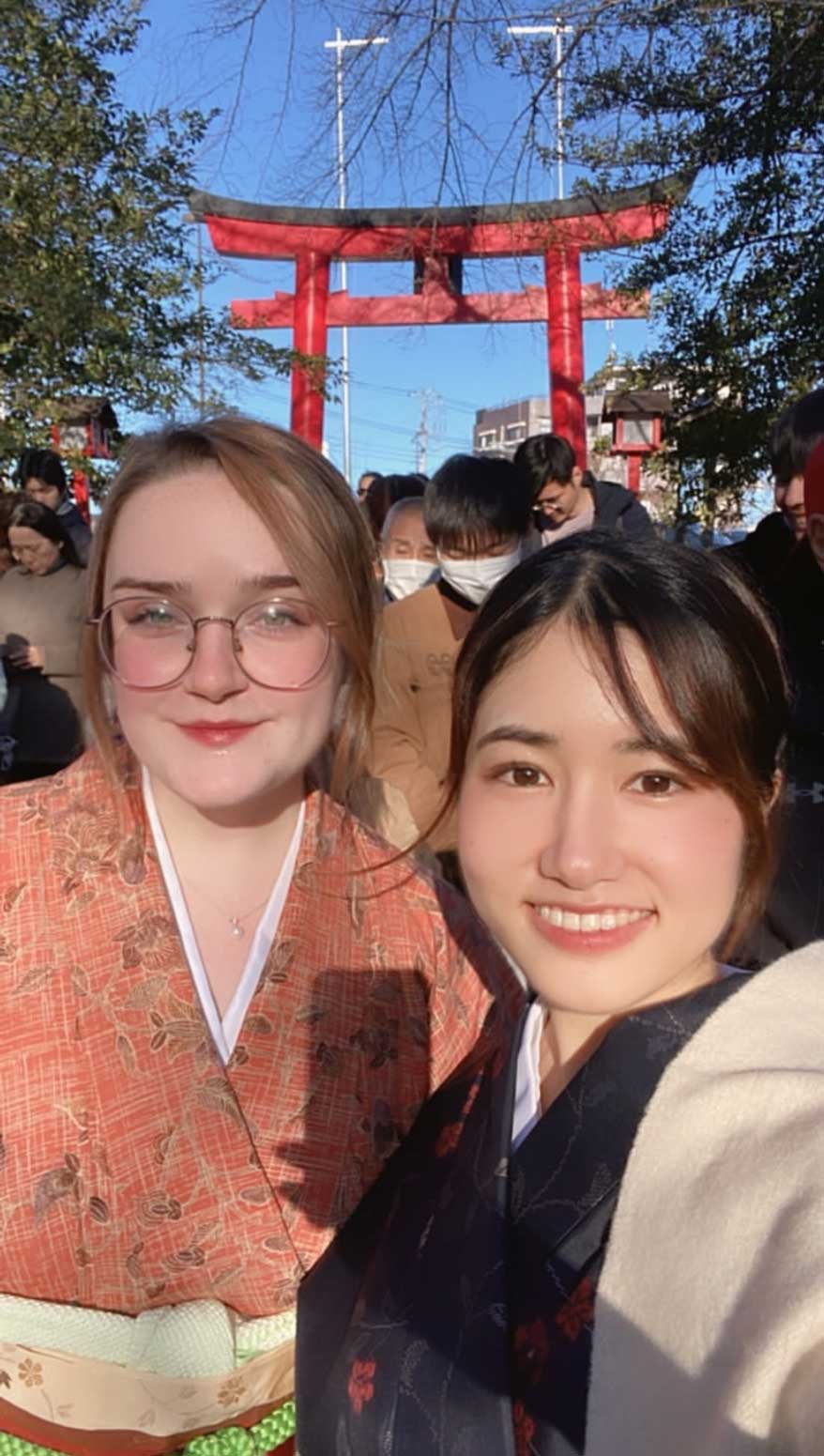 Two Women standing under Japanese architecture.