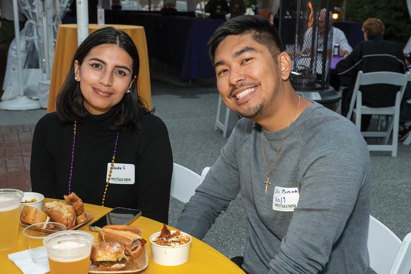 a woman and man with nametags smile for the camera