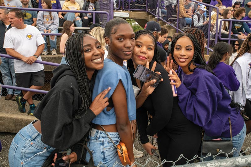 4 west chester university friends pose for a picture at the homecoming game