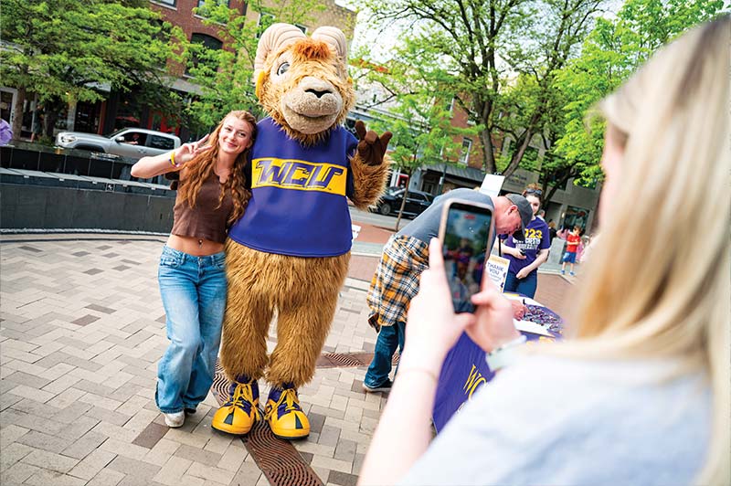 A young woman with long red hair poses for a picture with Rammy