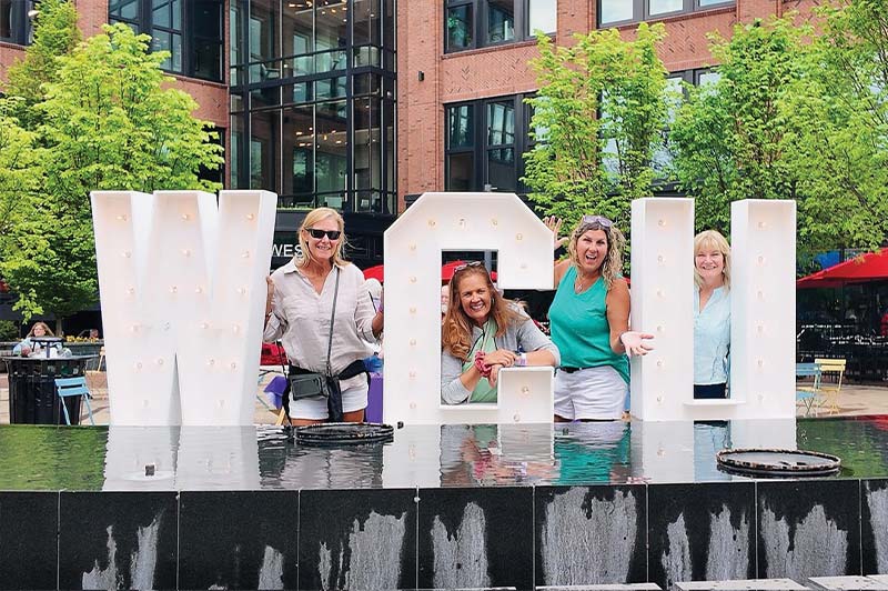 4 women pose with a large WCU letter sign