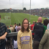 woman smiling in front of soccer field