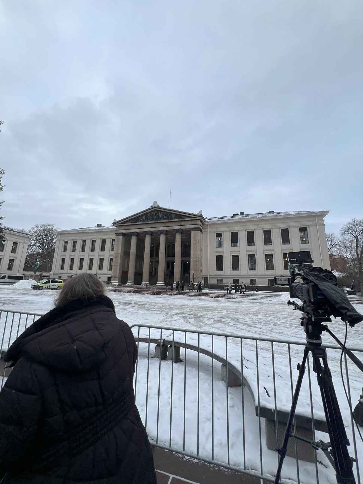 Cameraman in front of gated building