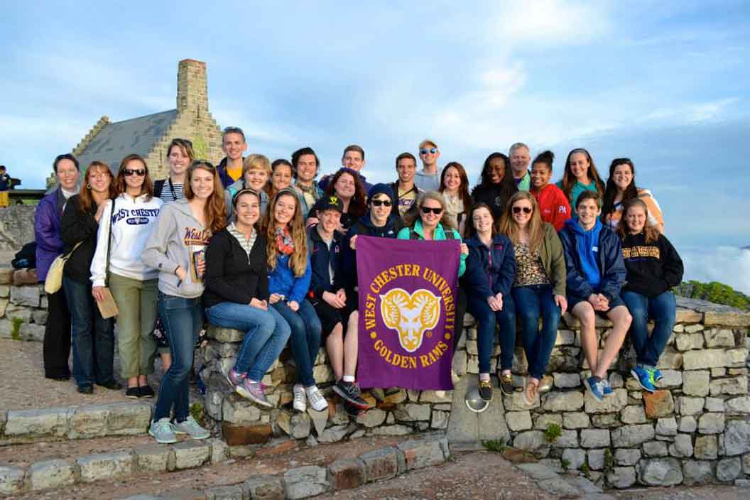 Group smiling with the WCU flag