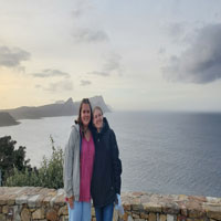 Two girls smiling in front of the sea