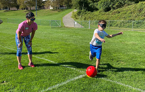 Adaptive PE child kicking a ball 