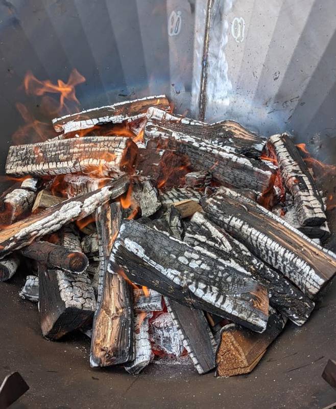 The 'mid-stages' of a burn. Once the largest portion of the top layer has a coating of ash (the white-gray portions in the photo), it's time to add another layer of fuel.