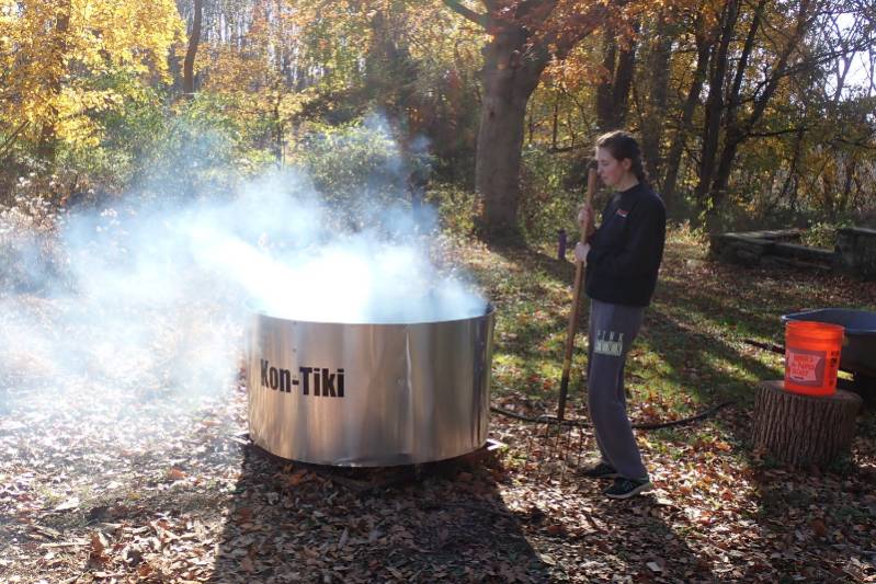 Miranda watching over the biochar kiln at the end of a burn