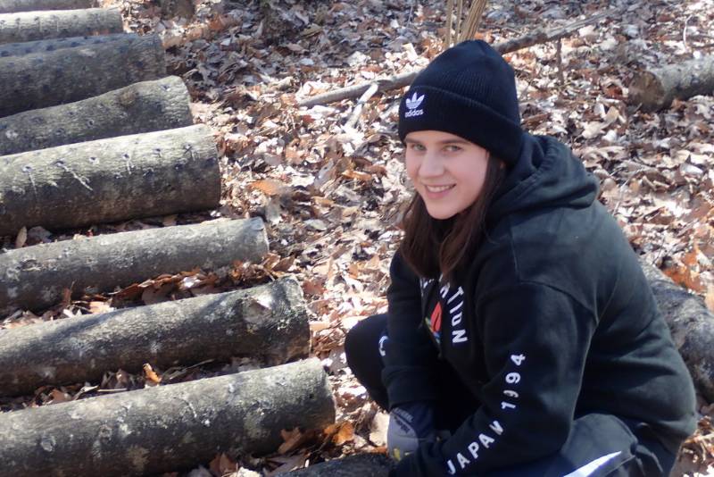 Rachel Resuta examining logs that had been inoculated with fungal spawn (Oyster mushrooms)