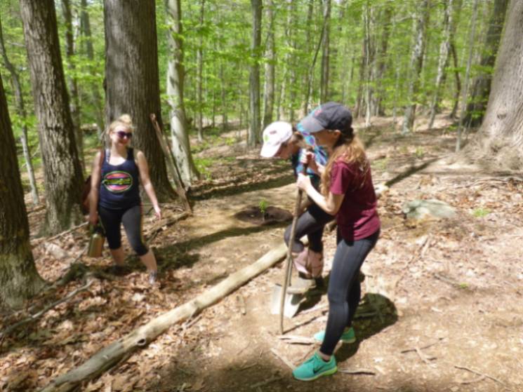 Students from the Earth Club planting trees along a 'decomisioned' trail.