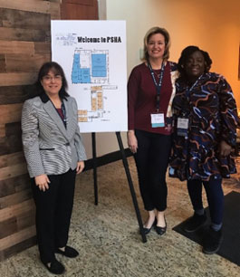 3 women standing in front of a presentation poster.