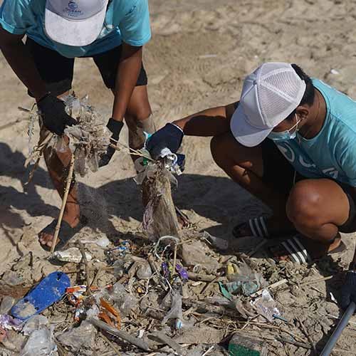 2 workers cleaning up litter from shore area