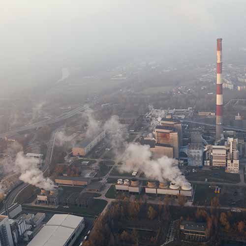 aerial view of factories spewing smoke into the air