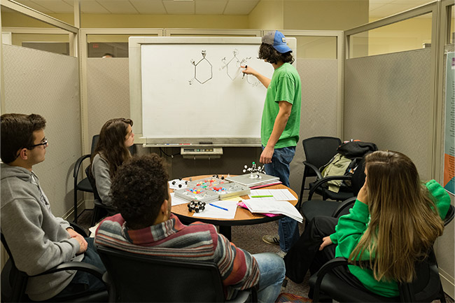 Chemistry students working on white board