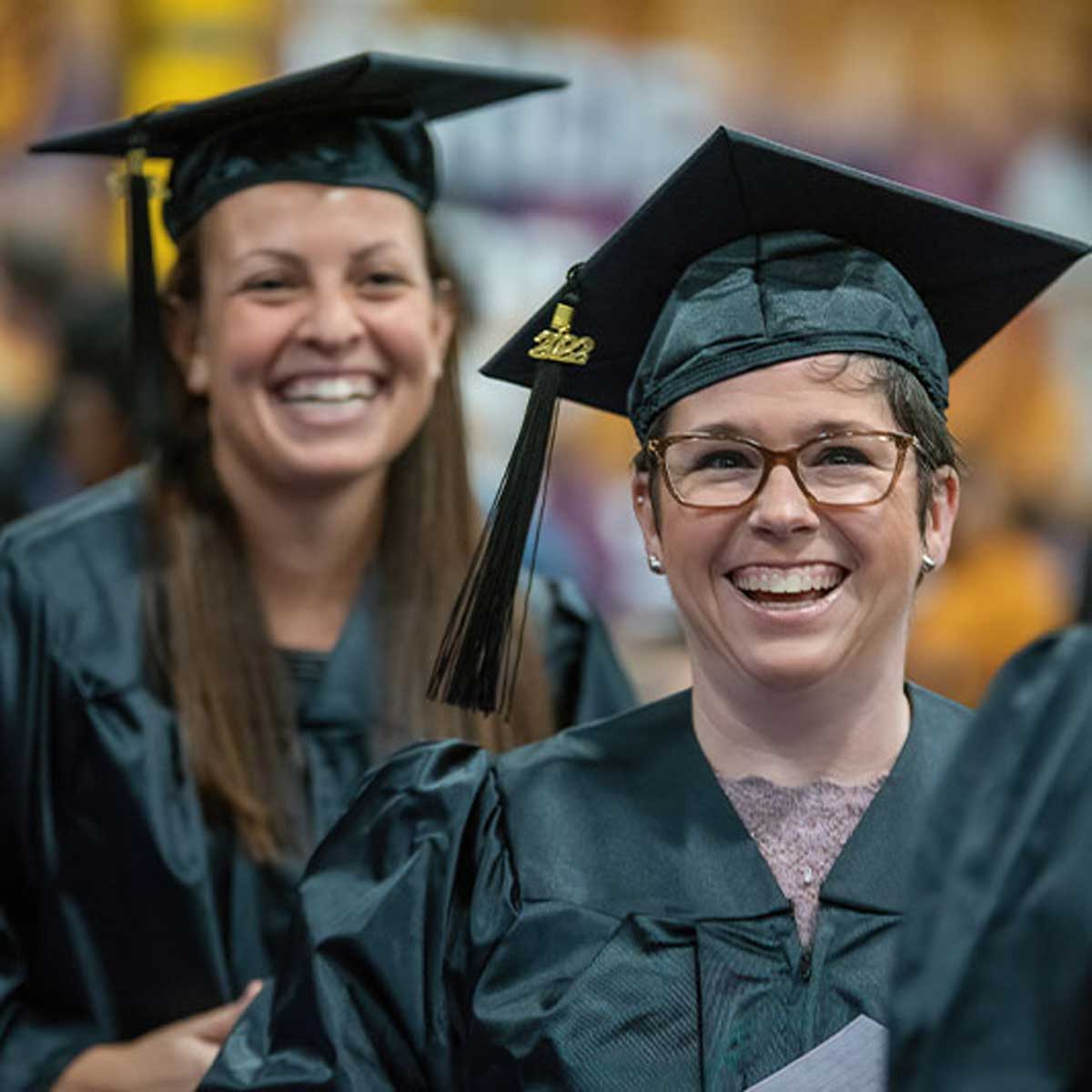 Graduate students at commencement ceremony smiling