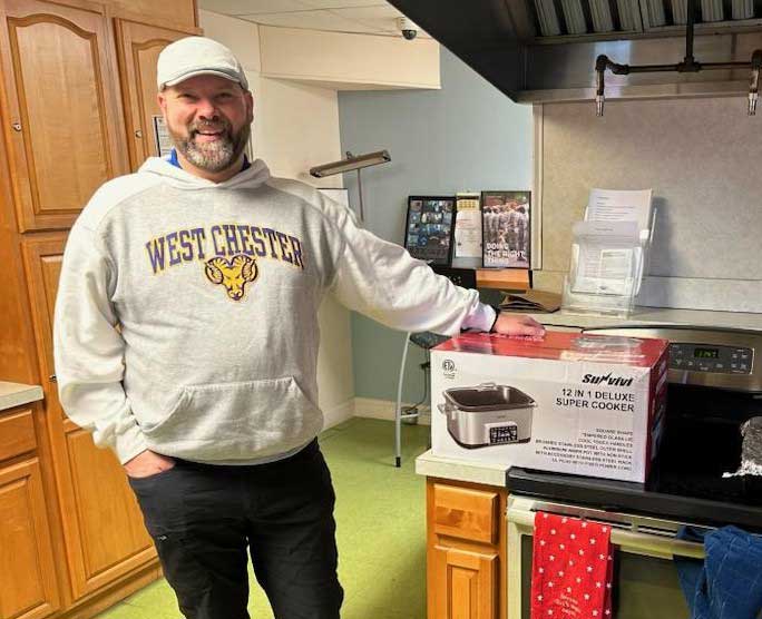 SVG Past President John Crouser standing with dry goods donation to Veterans Center